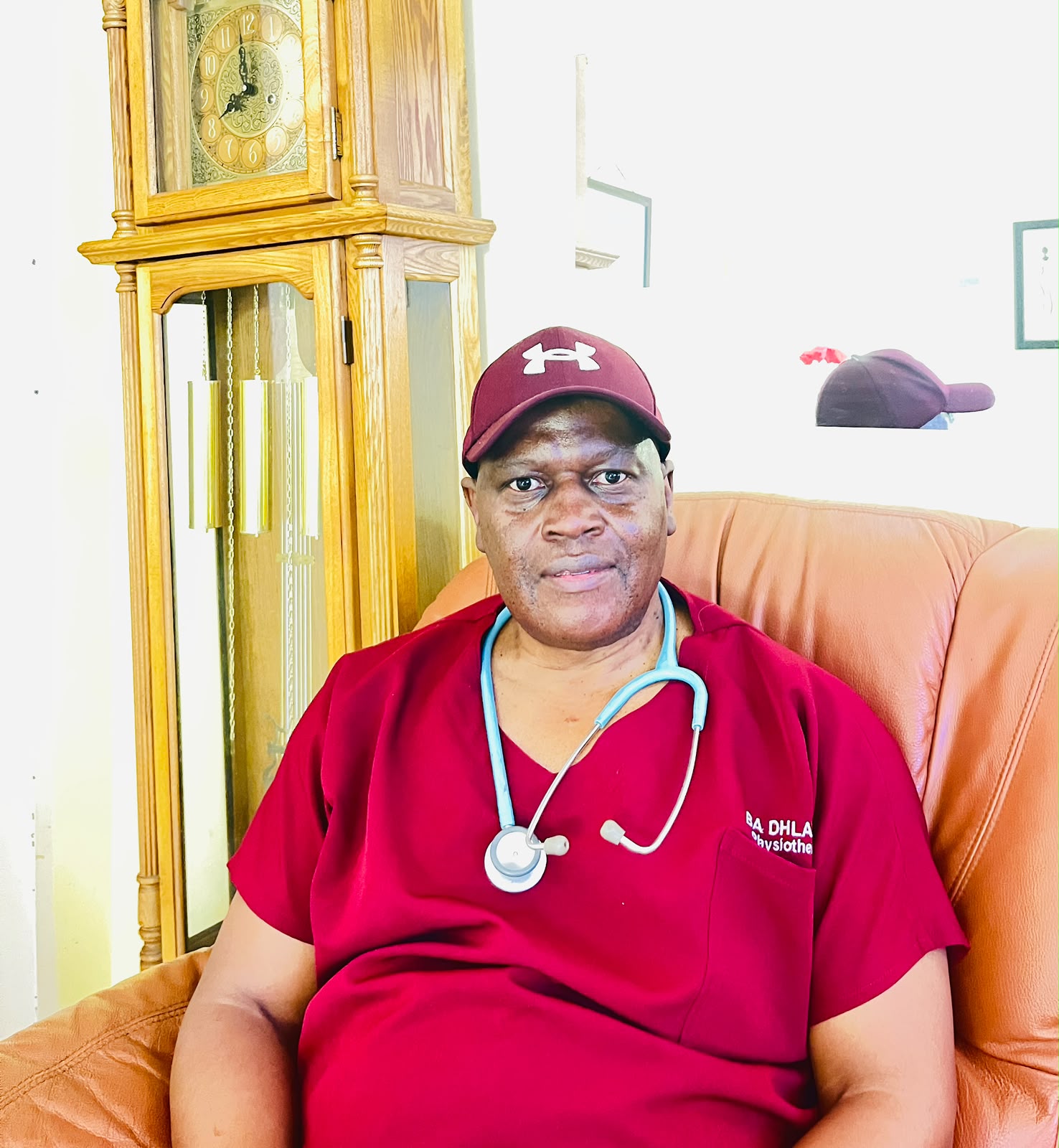 Mr Bhekisisa Arnold Dhladhla, physiotherapist, in maroon practice scrubs